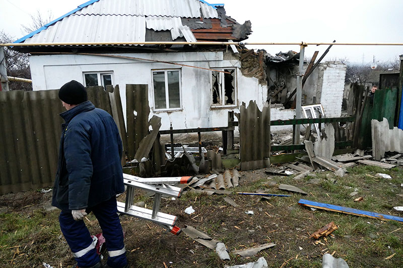 Мужчина у дома, поврежденного в результате обстрела украинскими силовиками