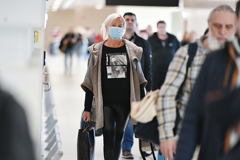 Девушка в медицинской маске в аэропорту