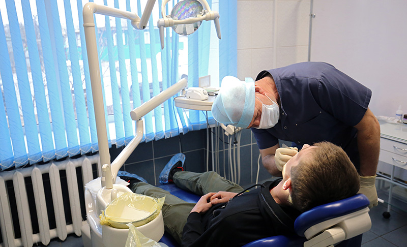 Хирург-стоматолог во время осмотра пациента
