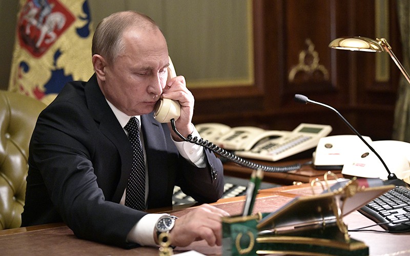 Владимир Путин разговаривает по телефону 