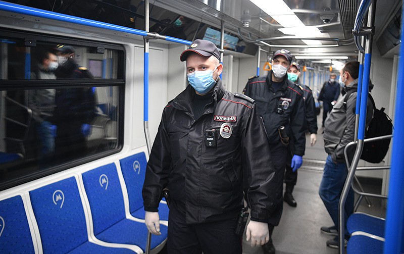 Сотрудники полиции в защитных масках в вагоне московского метро