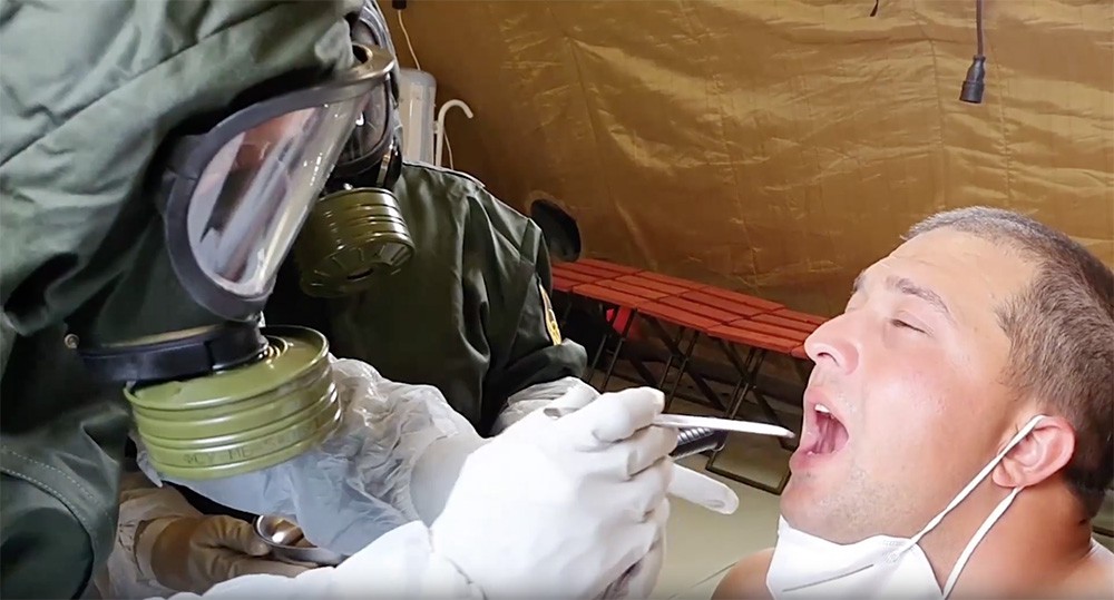 Военные медики обследуют пациента в полевом госпитале