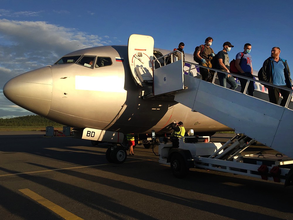 Пассажиры выходят из самолета