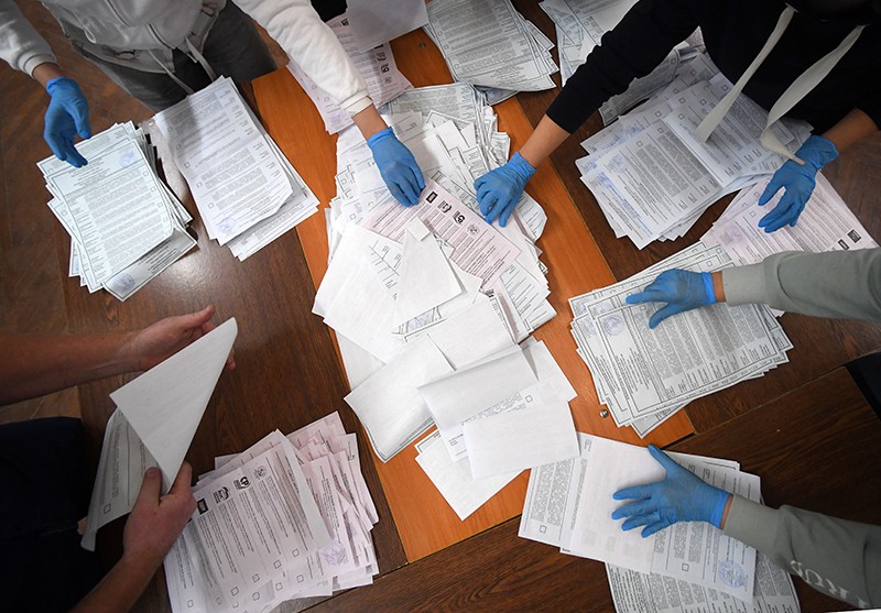 Члены участковой избирательной комиссии подсчитывают бюллетени на избирательном участке