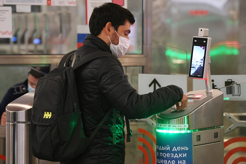 Молодой человек у турникета с установленным дистанционным тепловизором на станции метро "Спартак" в Москве
