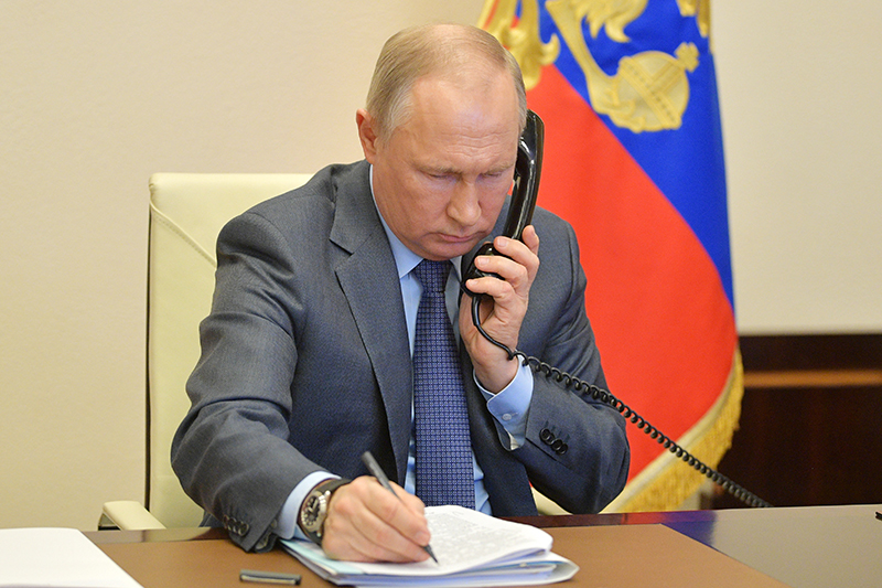 Владимир Путин во время разговора по телефону 