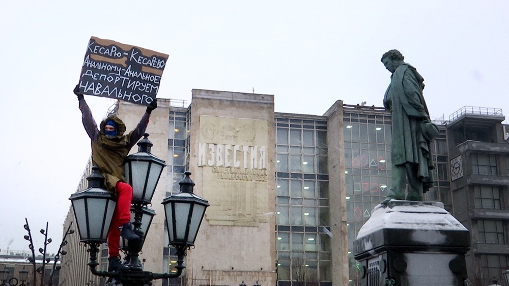 Участник несанкционированной акции с плакатом против Алексея Навального