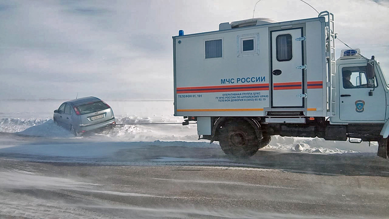 Сотрудники МЧС России эвакуируют автомобиль из снежного заноса