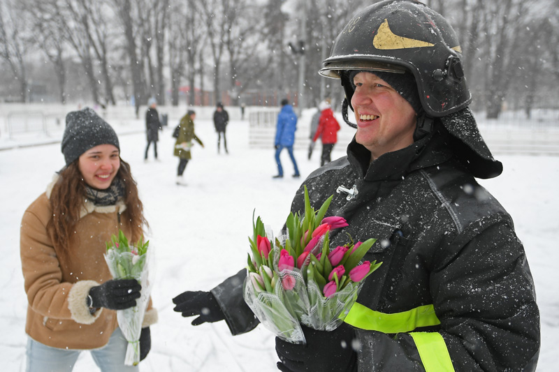 Сотрудник МЧС России поздравляет девушку с 8 марта 