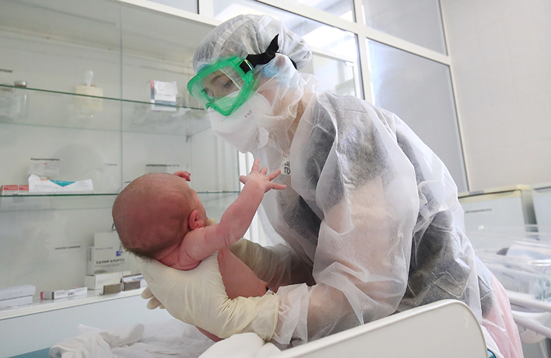 Медик ухаживает за новорожденным ребенком