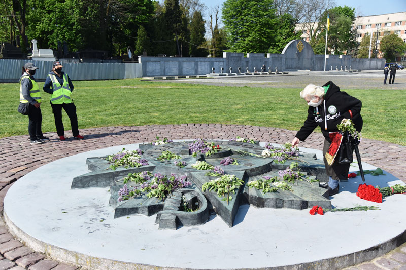 Женщина возлагает цветы на военном кладбище "Марсово поле" во Львове