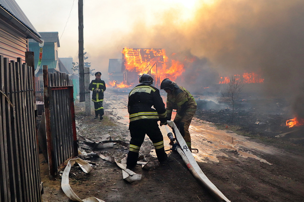 Сотрудники МЧС тушат горящие дома