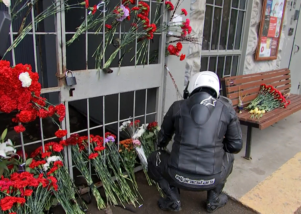 Цветы на месте убийства мотоциклиста на парковке